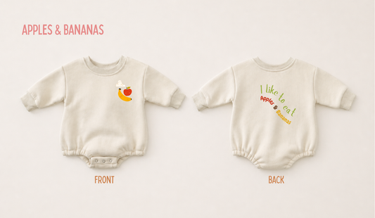 Front and back view of a cream fleece baby romper featuring playful Apples & Bananas graphics on a soft neutral background.