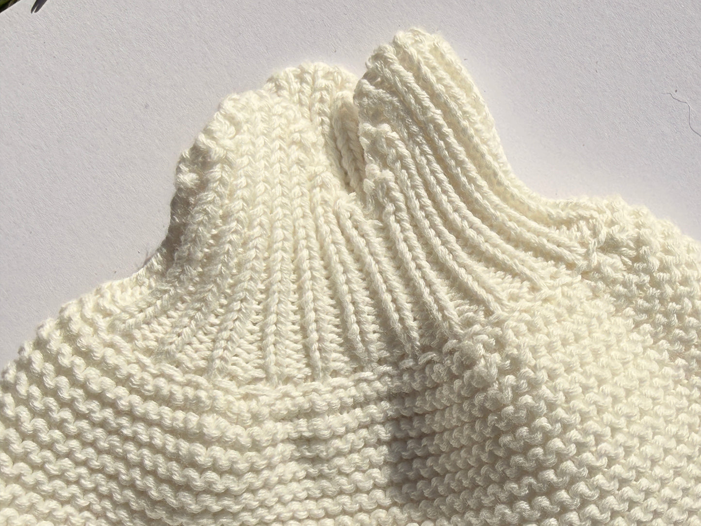 Detail of the soft cream 100% cotton knit texture and rolled neck on the Bubs on Cloud toddler sweater.